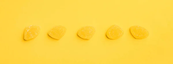 Tiro panorâmico de deliciosas geléias açucaradas em linha no fundo amarelo — Fotografia de Stock