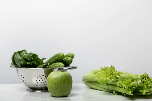 Green apple near fresh vegetables and spinach leaves on white — Stock Photo