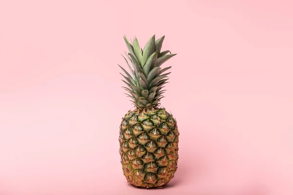 Fresh tasty and raw pineapple with green leaves on pink — Stock Photo
