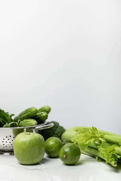 Süßer Apfel in der Nähe von grünen Limetten und Gurken auf weiß — Stockfoto