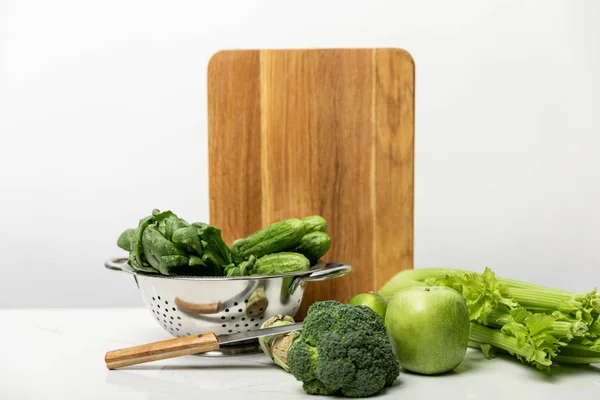 Green broccoli near ripe apple and fresh vegetables on white — Stock Photo