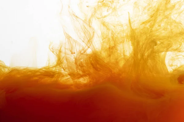 Close up view of orange paint swirls in water — Stock Photo