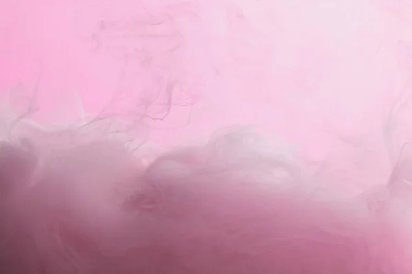 Vista de cerca de la mezcla de pintura rosa en agua aislada en rosa - foto de stock
