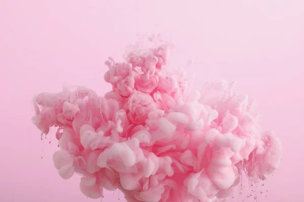 Vista de perto de tinta fumegante rosa em água isolada em rosa — Fotografia de Stock