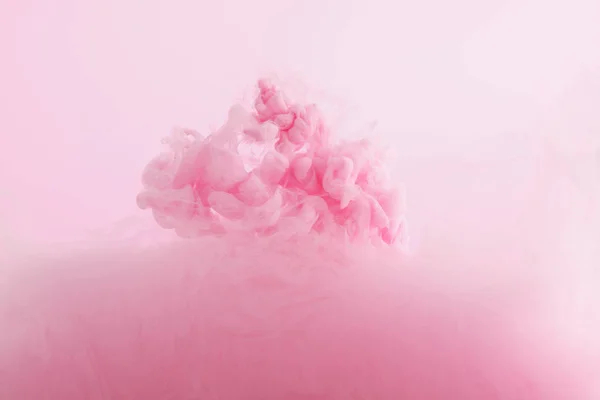 Close up view of pink paint swirls mixing in water — Stock Photo