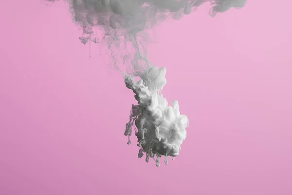 Vista de perto do respingo de tinta branca na água isolada em rosa — Fotografia de Stock
