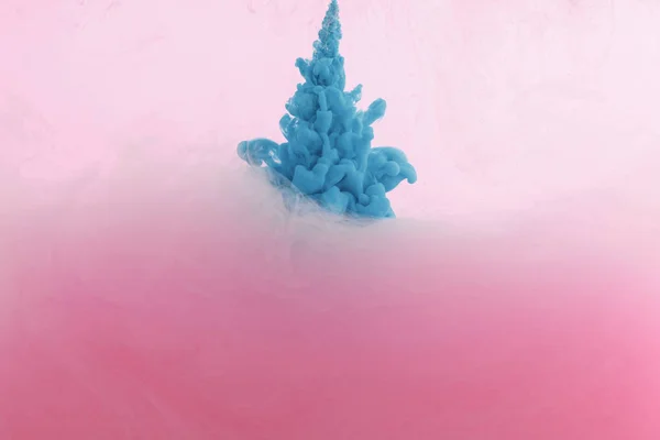 Close up view of blue paint splash in water isolated on pink — Stock Photo