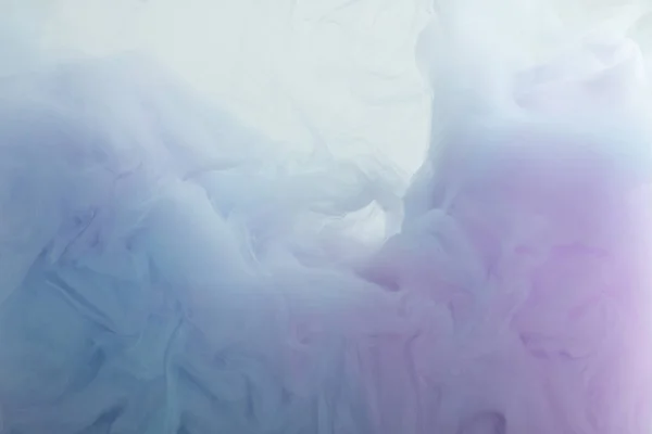 Close up view of light blue and purple paint swirls in water — Stock Photo