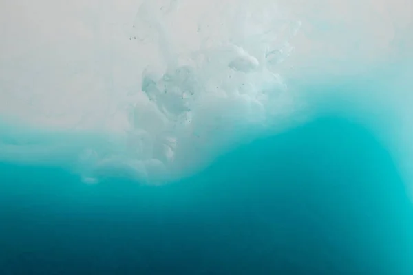 Vue rapprochée des tourbillons de peinture blanche et bleue dans l'eau — Photo de stock