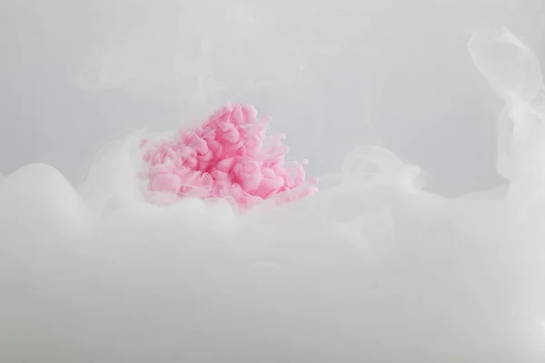 Vista de cerca de la mezcla de pintura rosa y blanca aislada en gris - foto de stock