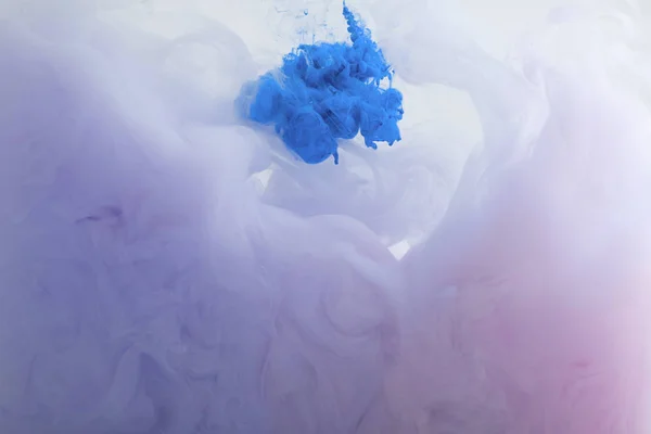 Close up view of blue and purple watercolor paint swirls in water — Stock Photo