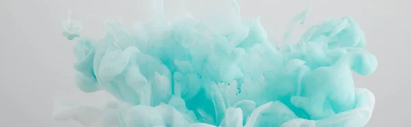 Вид на светло-голубые вихри краски, изолированные на сером — стоковое фото
