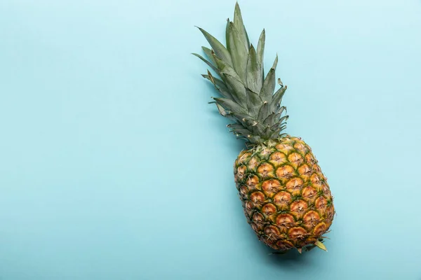 Draufsicht auf ganze reife tropische Ananas auf blauem Hintergrund mit Kopierraum — Stockfoto