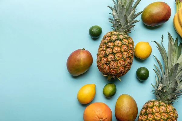 Draufsicht auf exotische Früchte auf blauem Hintergrund mit Kopierraum — Stockfoto