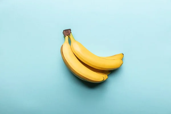 Вид зверху на стиглі жовті банани на синьому фоні — стокове фото