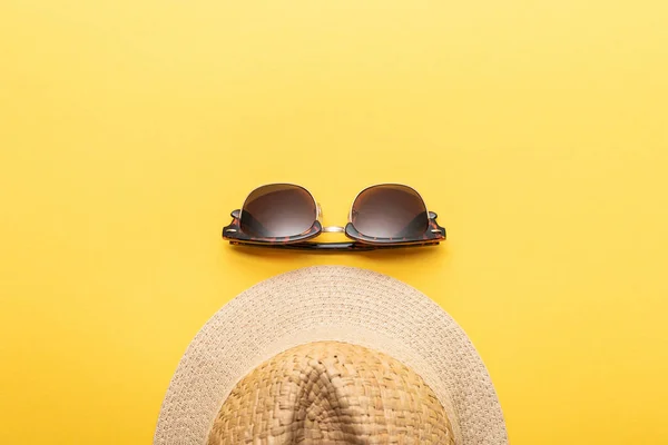 Vista superior del sombrero de paja de verano y gafas de sol sobre fondo amarillo - foto de stock