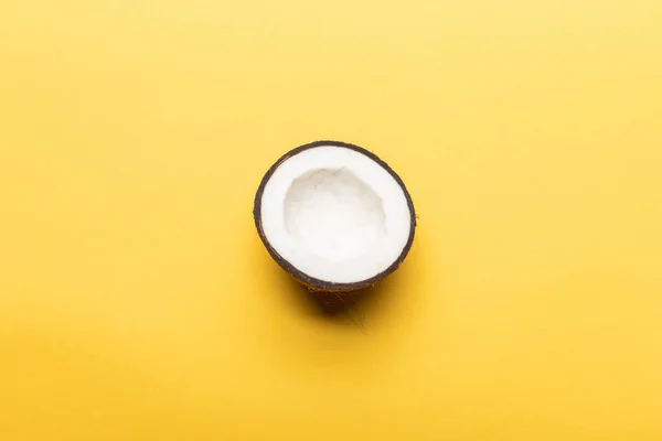 Vue du dessus de la moitié de noix de coco mûre sur fond jaune avec espace de copie — Photo de stock