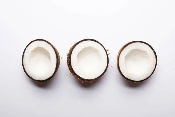 Вид зверху на стиглі кокосові половинки на білому тлі з пробілом для копіювання — стокове фото
