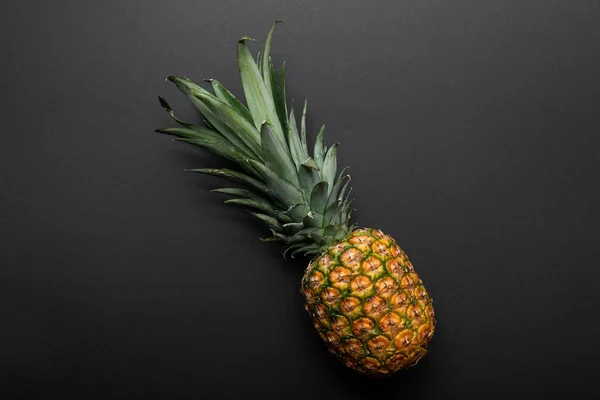 Top view of ripe yellow pineapple on black background — Stock Photo