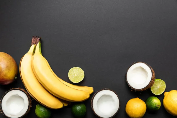 Top view of ripe tropical fruits on black background with copy space — Stock Photo