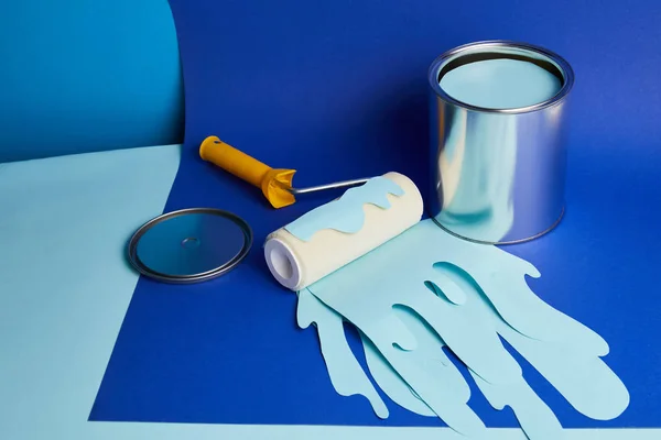 Silver can and roller with dripping paper cut paint on bright blue background — Stock Photo