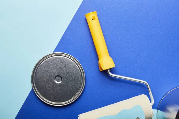 Top view of metal cap near roller on bright blue background — Stock Photo