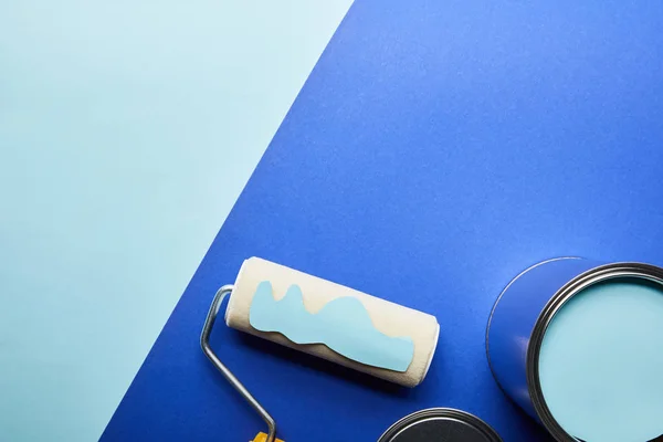 Top view of roller with blue paper cut paint near metal can — Stock Photo