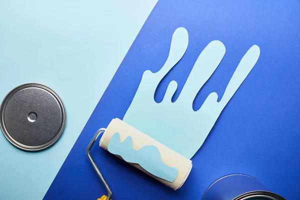 Top view of metal shiny cap and dripping paper cut paint near roller — Stock Photo