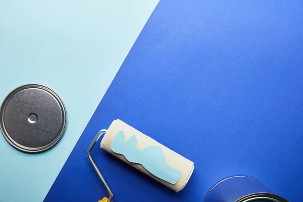 Top view of metal shiny cap and blue paper cut paint on roller — Stock Photo