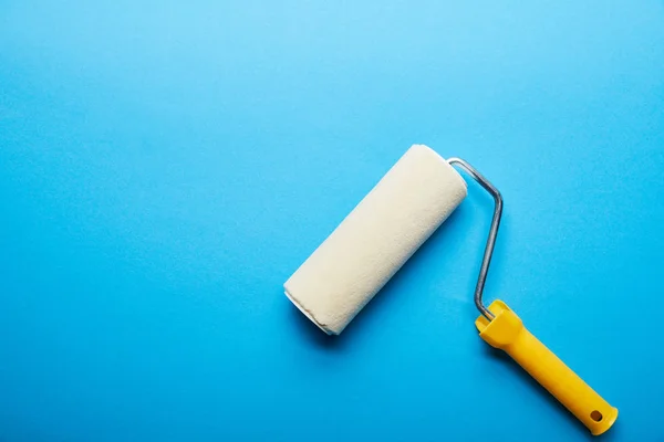 Top view of roller on bright blue background with copy space — Stock Photo