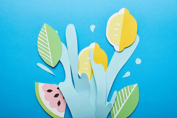 Top view of paper cut water splash with lemons, leaves and watermelon on bright blue background — Stock Photo