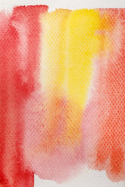 Close up view of pale yellow and red watercolor paint brushstrokes on textured background — Stock Photo