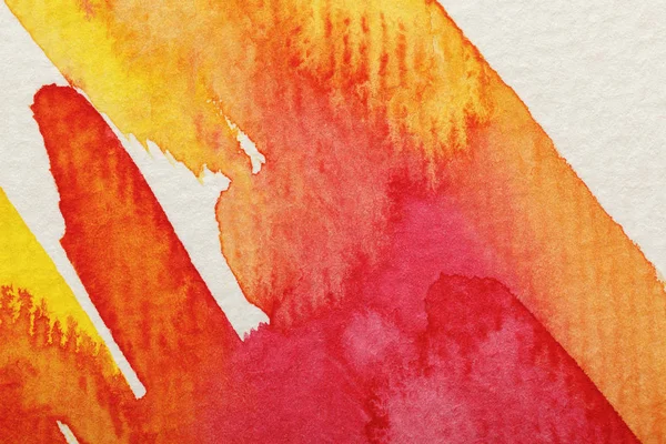 Close up view of yellow and red watercolor paint brushstrokes on textured background — Stock Photo