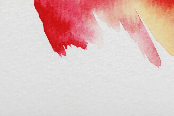 Close up view of yellow and red watercolor paint brushstrokes on white background — Stock Photo