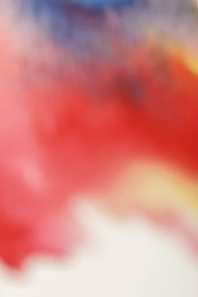 Vista de cerca de los derrames de pintura de acuarela borrosa amarilla, azul y roja - foto de stock