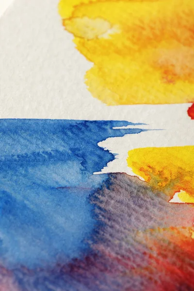 Vue rapprochée des traits de pinceaux aquarelle jaunes, bleus et rouges sur fond blanc — Photo de stock