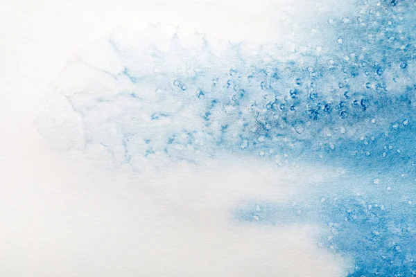 Vue rapprochée du déversement de peinture aquarelle bleue avec des points sur fond blanc — Photo de stock