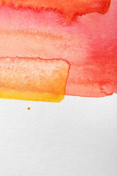 Vue rapprochée des déversements de peinture aquarelle jaune et rouge sur fond blanc avec espace de copie — Photo de stock