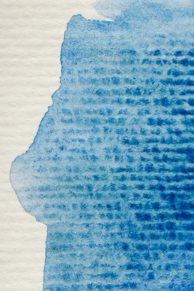 Vista de cerca del derrame de pintura de acuarela azul sobre fondo de papel texturizado - foto de stock
