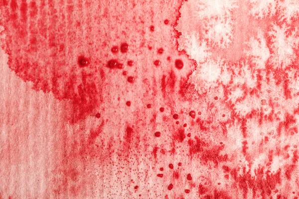 Vista da vicino della fuoriuscita di vernice ad acquerello rosso e gocce su sfondo di carta strutturata — Foto stock