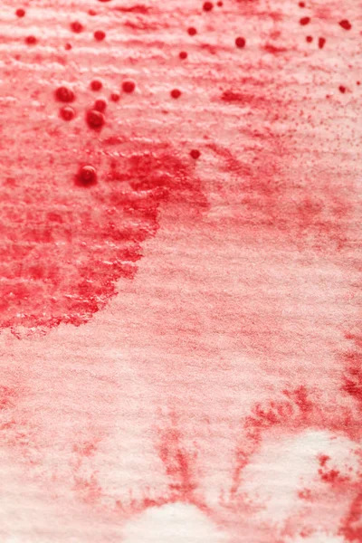 Red watercolor paint spill on textured paper background — Stock Photo