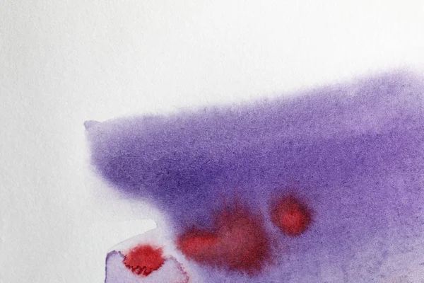 Vue rapprochée de pourpre et rouge aquarelle déversements de peinture sur fond blanc — Photo de stock