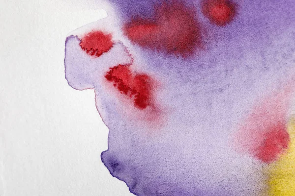 Close up view of yellow, purple and red watercolor paint spills on white background — Stock Photo