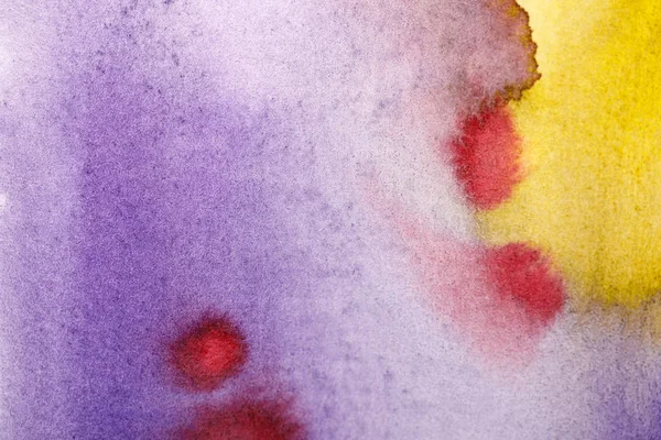 Close up view of yellow, purple and red watercolor paint spills — Stock Photo