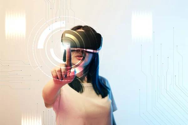 Young woman in vr headset pointing with finger at network illustration on beige and blue background — Stock Photo