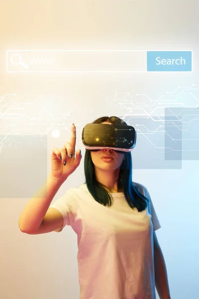 Young woman in vr headset pointing with finger at network illustration with search bar above head on beige and blue background — Stock Photo