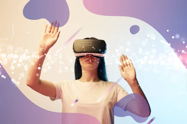 Young woman in virtual reality headset pointing with hands at glowing and purple abstract illustration on beige and blue background — Stock Photo