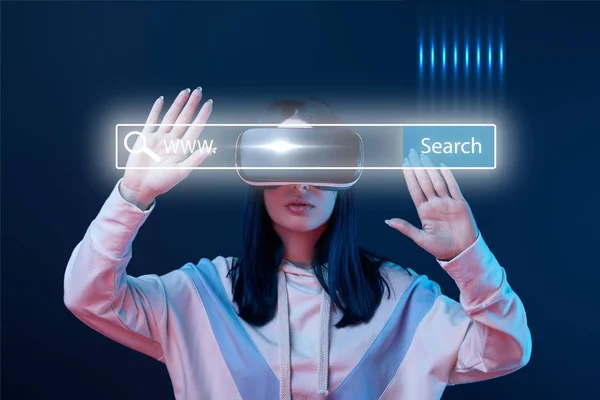 Young woman in virtual reality headset gesturing near glowing search bar illustration on dark background — Stock Photo