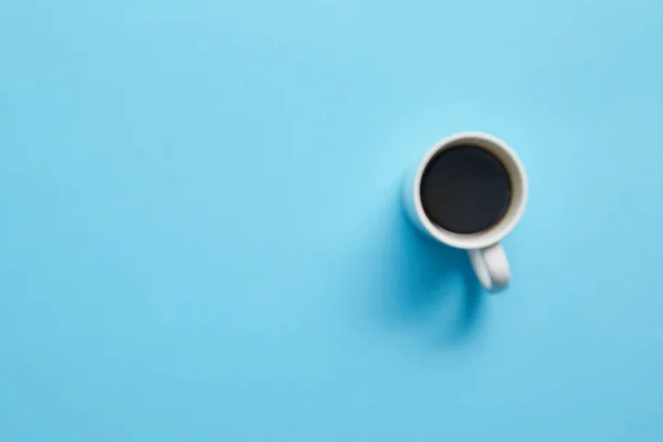 Vista superior da xícara de café delicioso quente no fundo azul — Fotografia de Stock