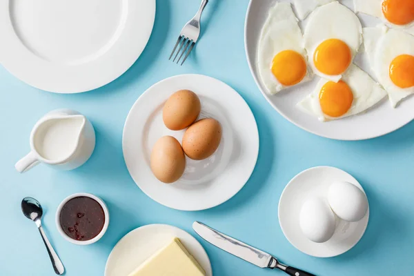 Vista superior del desayuno servido con plato vacío sobre fondo azul - foto de stock